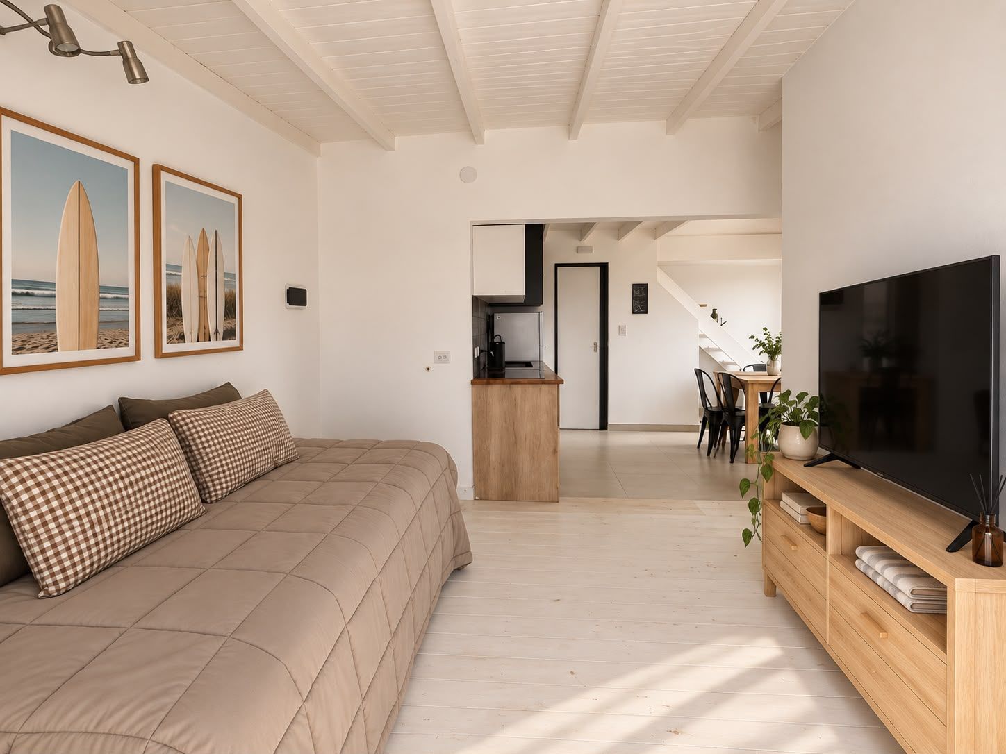 Living de un departamento con sofá cama y cuadros de surf